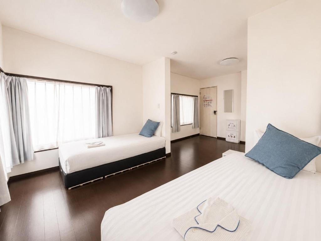 a bedroom with two beds and two windows at D Hotel - Vacation STAY 78387v in Tokyo