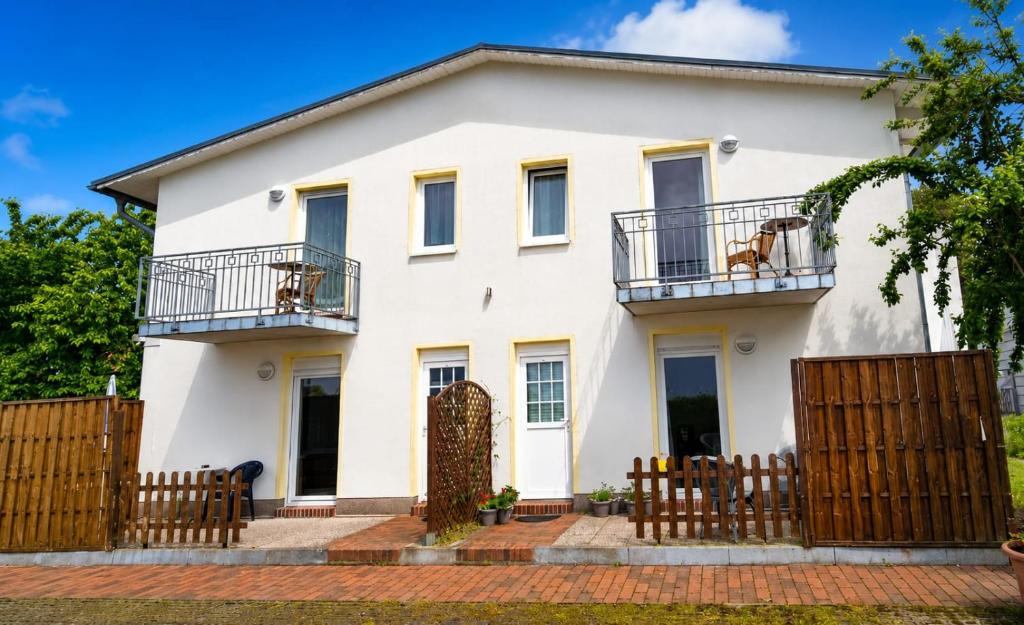 a white house with a fence at Pension NoAs in Sassnitz