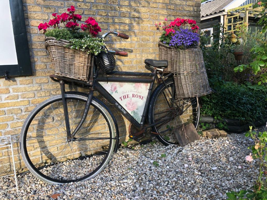 a bike with two baskets and flowers on it at The Rose in Mantgum