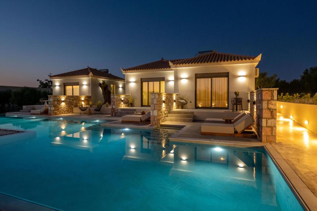 eine Villa mit Swimmingpool bei Nacht in der Unterkunft Koroni Poolside Suites in Koroni