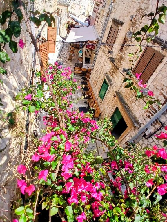 a bunch of pink flowers in front of a building at Hvar old Town Boutique in Hvar