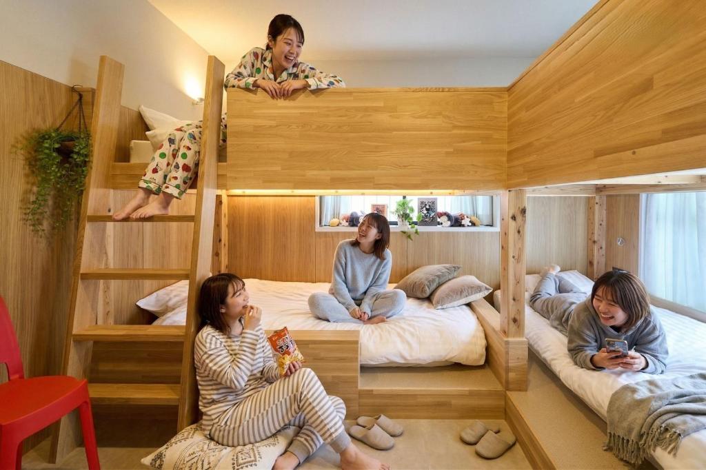 a group of people sitting on beds in a room at Inside Sangreen - Vacation STAY 22712 in Tokyo