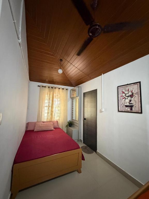 a bedroom with a red bed in a room at Koyiloth house by intertrip in Kalpetta