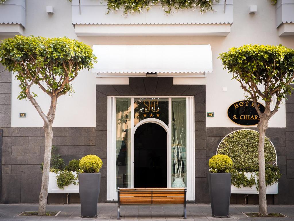 a wooden bench in front of a building at Hotel Santa Chiara in Nocera Inferiore