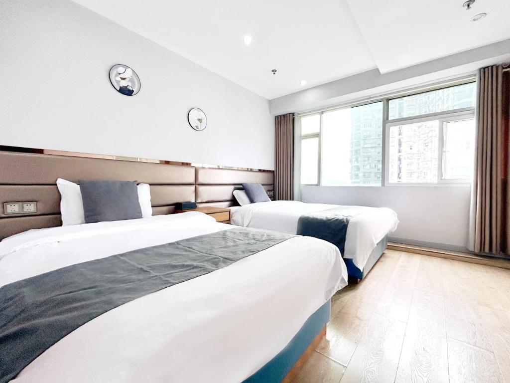 a hotel room with two beds and a window at 枳兮酒店 渝中区解放碑 in Chongqing
