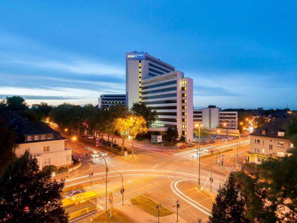 a city at night with a building and a street at Webers Hotel im Ruhrturm Essen by Accor in Essen