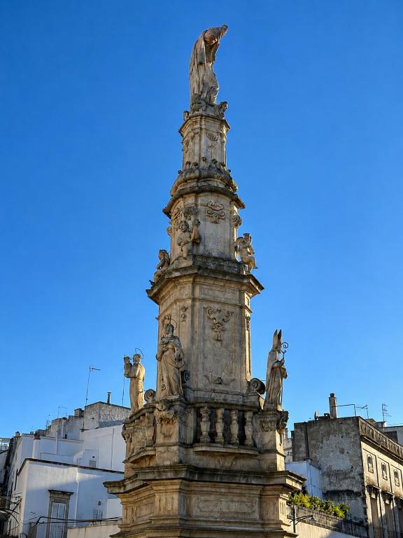a statue in front of a building at Colonna Apartment Ostuni in Ostuni