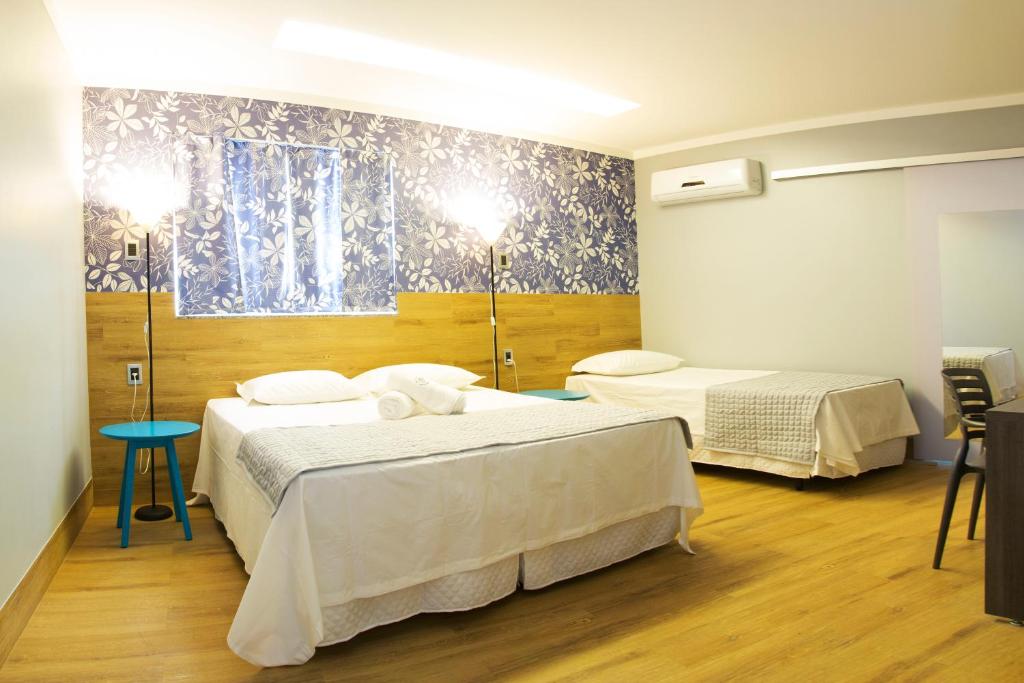 een kamer met 2 bedden in een kamer met bij Pontual Hotel in Bocaiúva