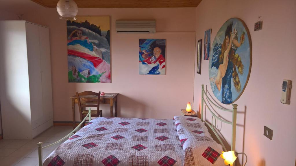 ein Schlafzimmer mit einem Bett mit einer Decke darauf in der Unterkunft Azienda Agrituristica Piccolo Ranch in San Pietro
