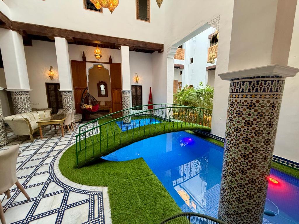 a swimming pool in the middle of a building with a bridge at Riad Old City Palace in Fez