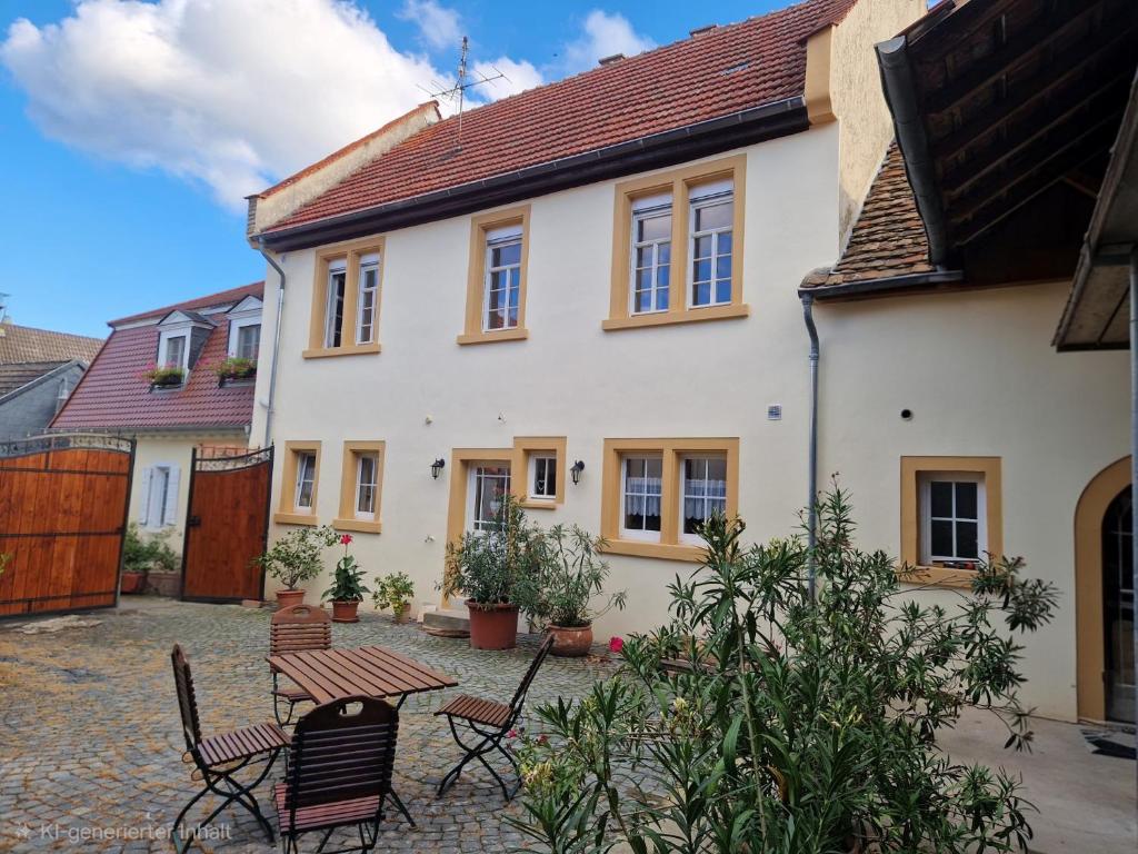 a house with a table and chairs in a courtyard at Gästehaus Ringhof in Flörsheim-Dalsheim