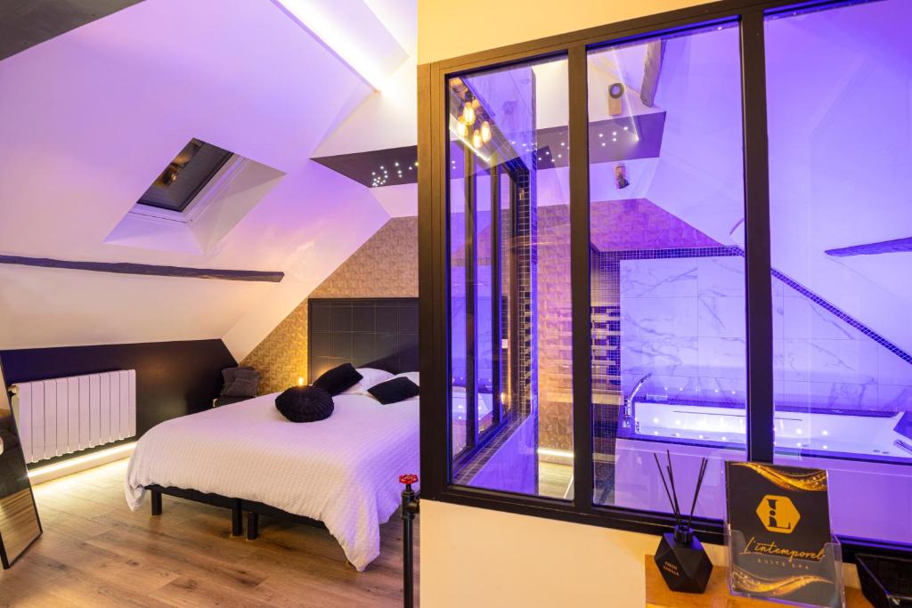 a room with a bed and a large window at L'Intemporel Éclipse Suite Spa Privatif in Champagne-sur-Oise