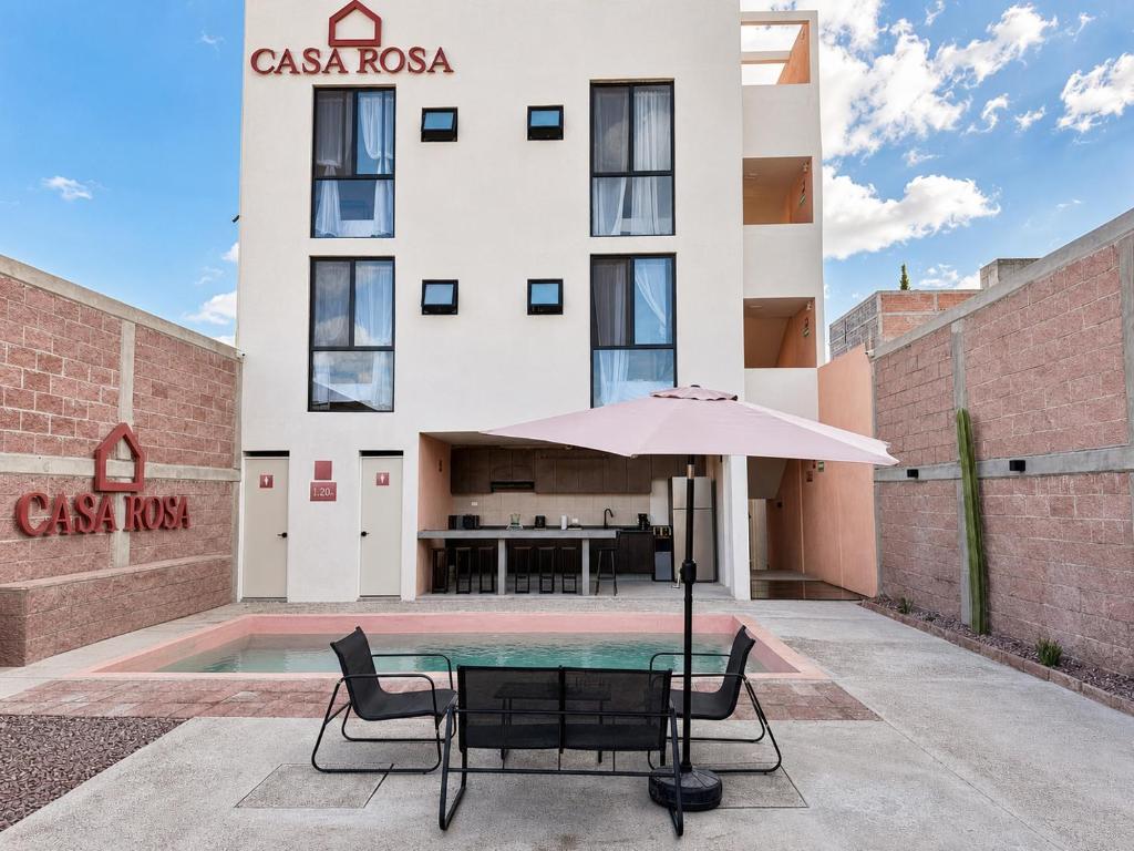 a table with an umbrella in front of a building at Casa Rosa in Aguascalientes
