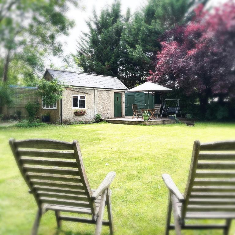 two chairs sitting in the grass in a yard at River Cabin Retreat in Shepperton