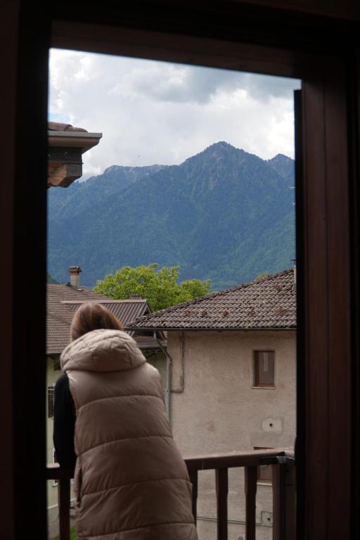 a person looking out a window at a mountain at Appartamento Villa Rendena in Porte di Rendena
