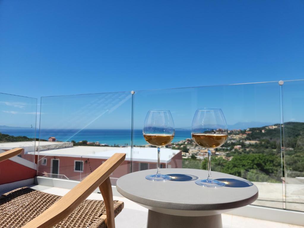 two glasses of wine sitting on a table on a balcony at Miranda Haus in Arillas