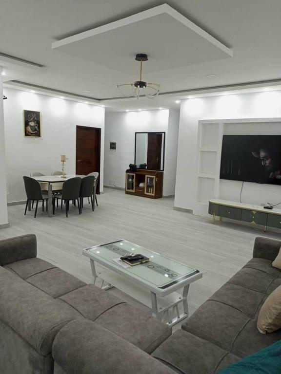 a living room with a couch and a table at CarteSurTable - Votre havre de paix aux portes de la ville - Villa haut standing in Yamoussoukro