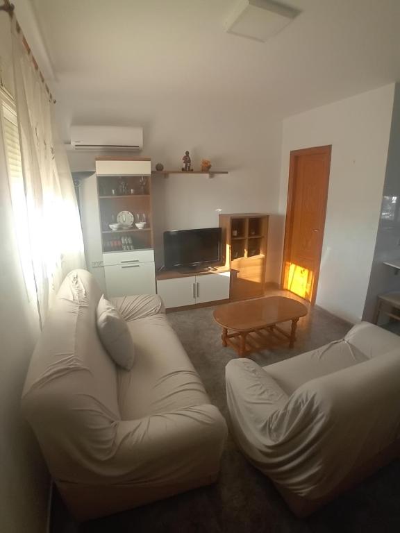 a living room with a white couch and a table at COSTACABANA Apartamento in Almería