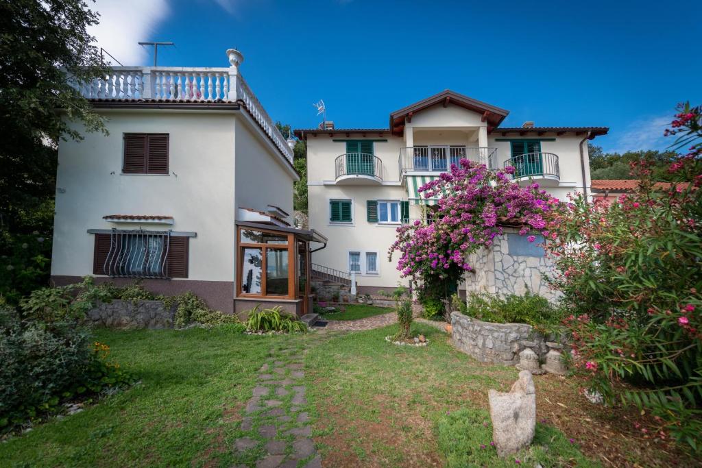 a large white house with a yard in front of it at House H-ELIOS in Lovran