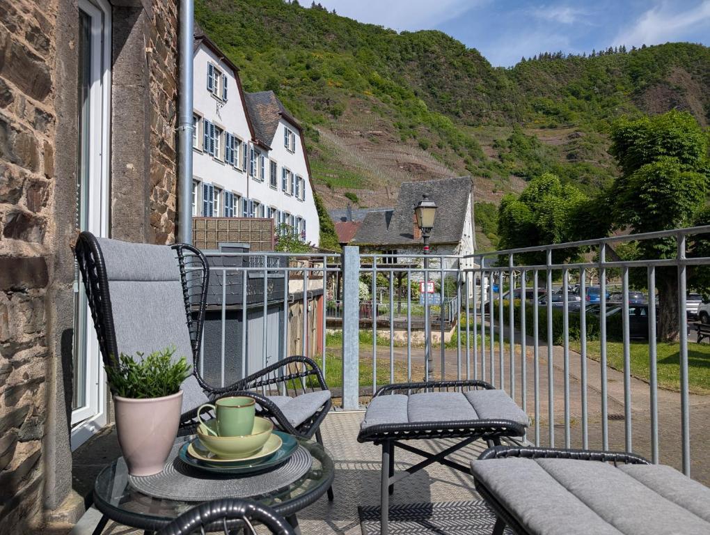 a balcony with two chairs and a table with a coffee table at Charme & Moselblick im Alten Winzerhaus am Calmont in Bremm