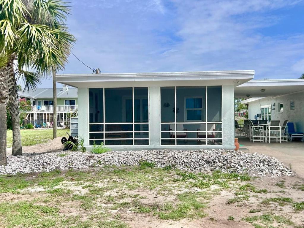 a house with a palm tree in front of it at Baked Beach Bungalow in St. George Island