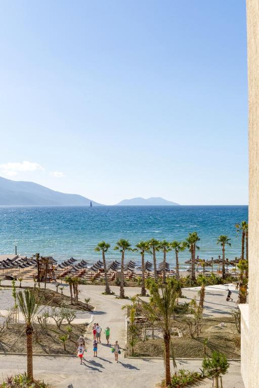 a view of a beach with palm trees and the ocean at Hotel Bella Vista in Orikum