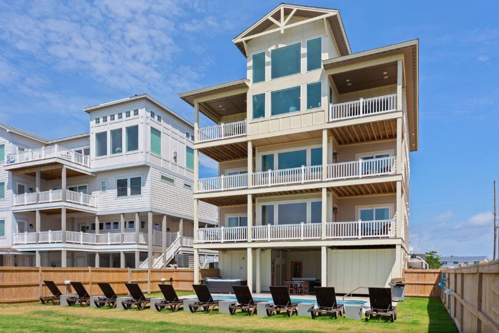 a large apartment building with chairs in front of it at 8910 - Aquasition in Hatteras