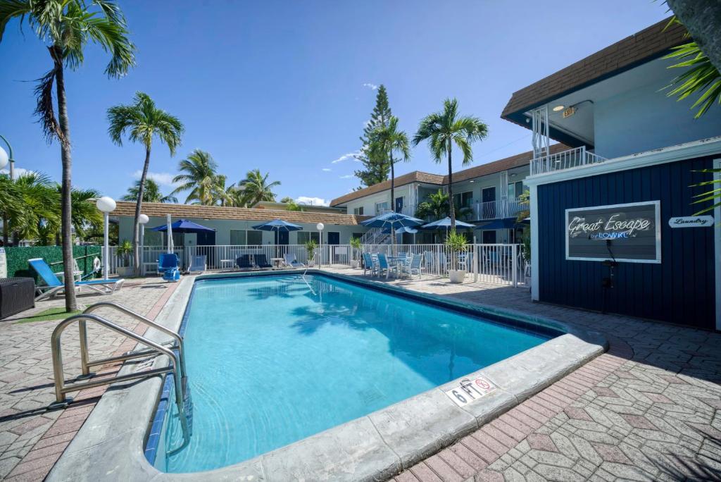 a swimming pool at a resort with palm trees at Great Escape Apartments By Lowkl in Fort Lauderdale