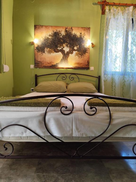 a bedroom with a bed with a painting on the wall at Asmanis Rooms in Tarti