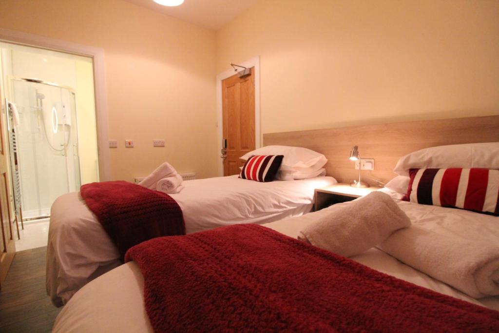 1 dormitorio con 2 camas y mantas rojas y blancas en Townlets Townhouse en Belfast