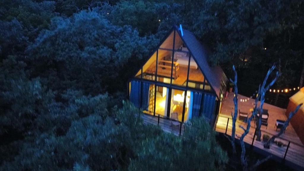 a house with lights on in a forest at night at Cabaña Gokotta, Punta del Bosque in Huasca de Ocampo