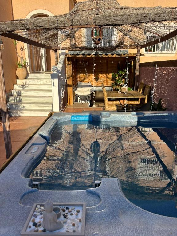 a pool in a house with a table at Bungalow en la Playa con Terraza Soleada, Jacuzzi, Solarium, Piscina comunitaria in Gran Alacant