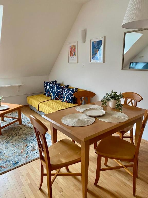a dining room with a table and chairs and a couch at Lake Veronika in Bled