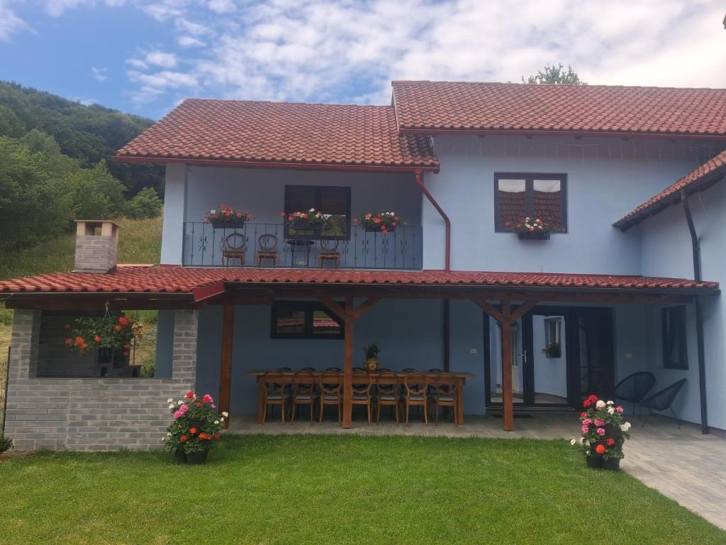 a house with a patio with chairs and a deck at Casa Ardelean in Sita Buzăului