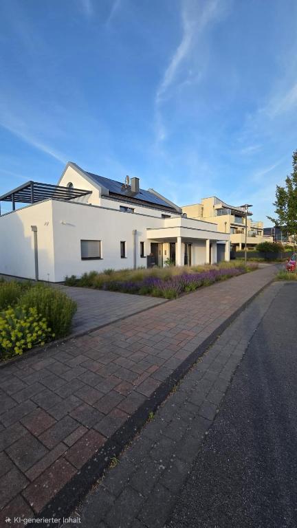 a white building with a road in front of it at Haus am Prekkesee in Xanten