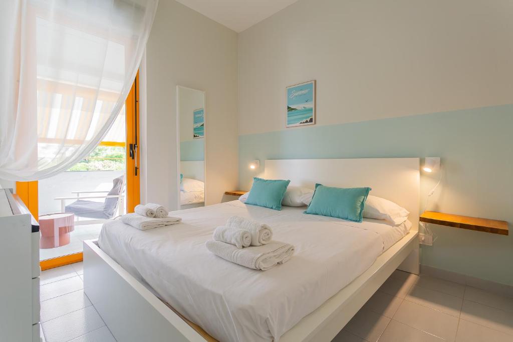 a bedroom with a large white bed with towels on it at Maréa - Boutique Stay in Torre a Mare