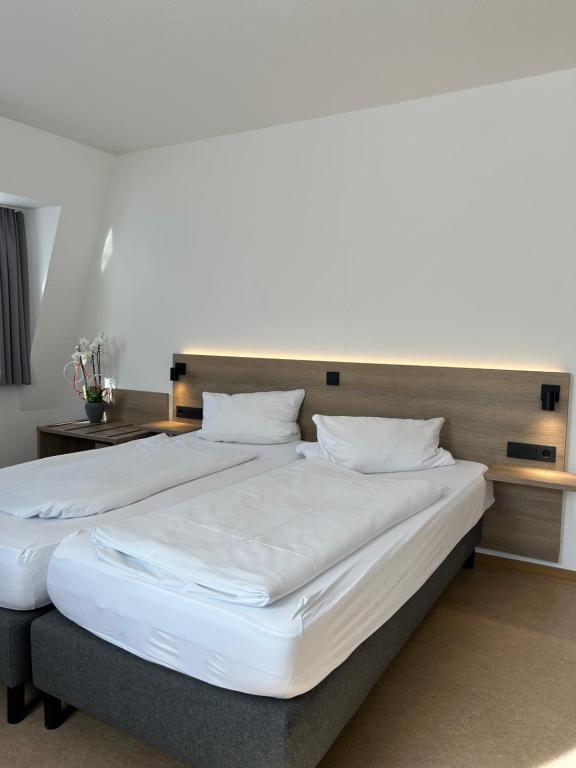 a large bed with white sheets and pillows at Zenntaler Hof in Neuhof an der Zenn
