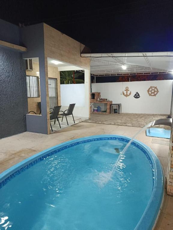 a swimming pool with a car spraying water into it at Jacumã Beach House in Conde