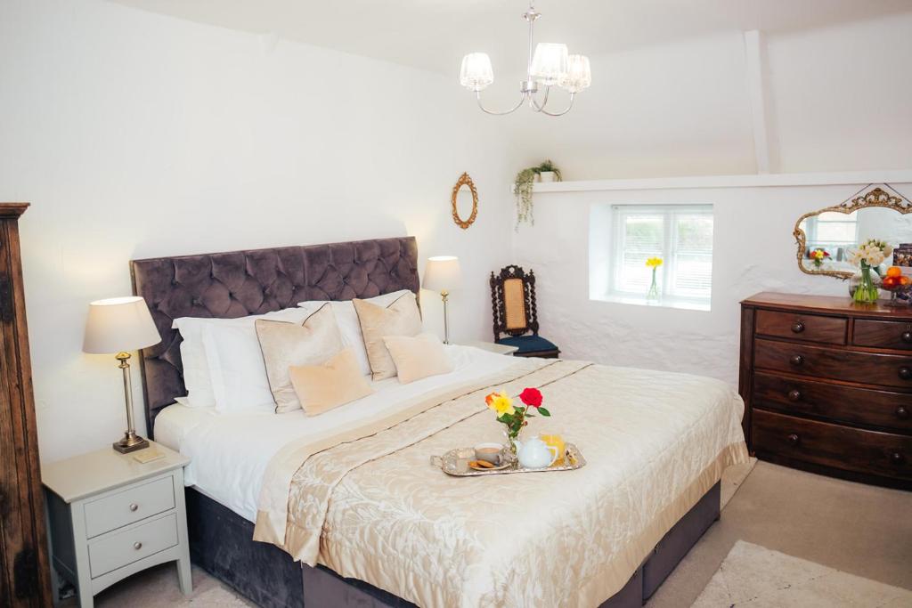 a bedroom with a bed with a vase of flowers on it at The Cott Inn in Totnes