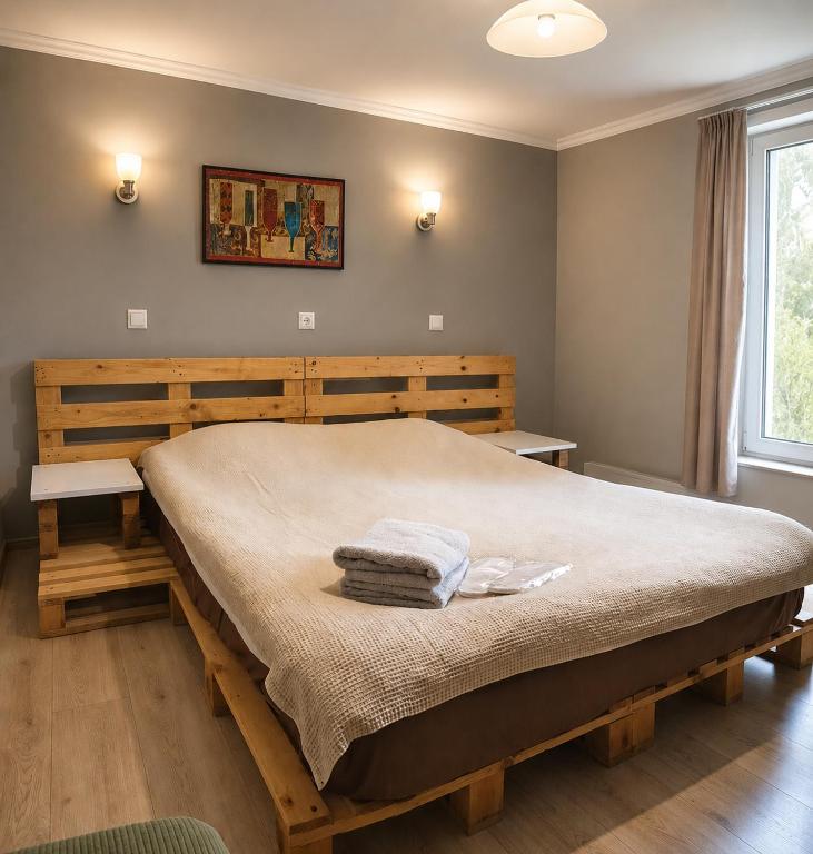 a bedroom with a large bed with a wooden frame at Welcome Guests in Tbilisi City