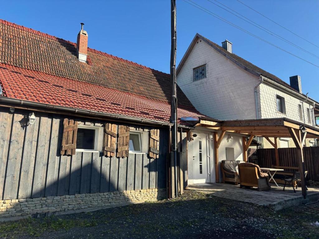 a white house with a roof with a patio at Neubeginn 2 - Zimmer B in Hildburghausen