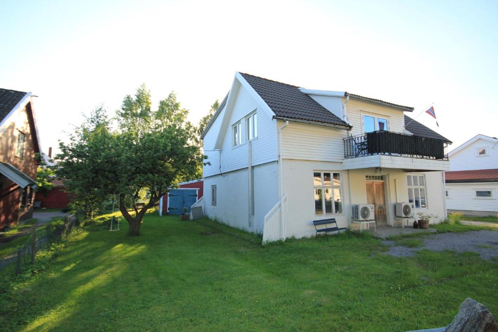 a white house with a yard in front of it at Smia in Søgne