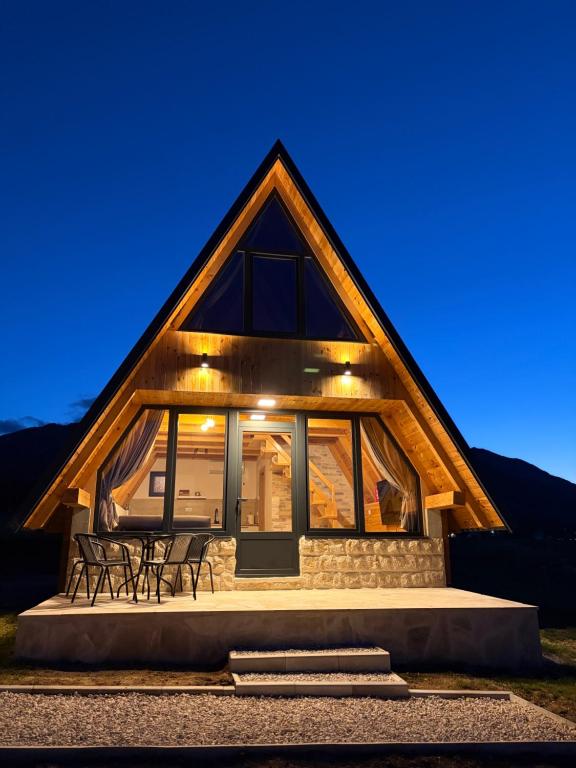 a cabin with a large glass door and two chairs at Maple Valley in Žabljak