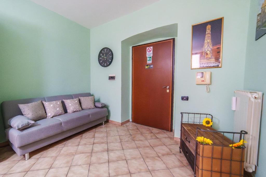 a living room with a couch and a clock on the wall at La Casetta del Suffragio in Viterbo