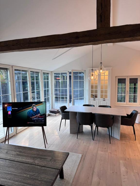 a living room with a dining table and a tv at The Copenhagen Retreat in Hvidovre