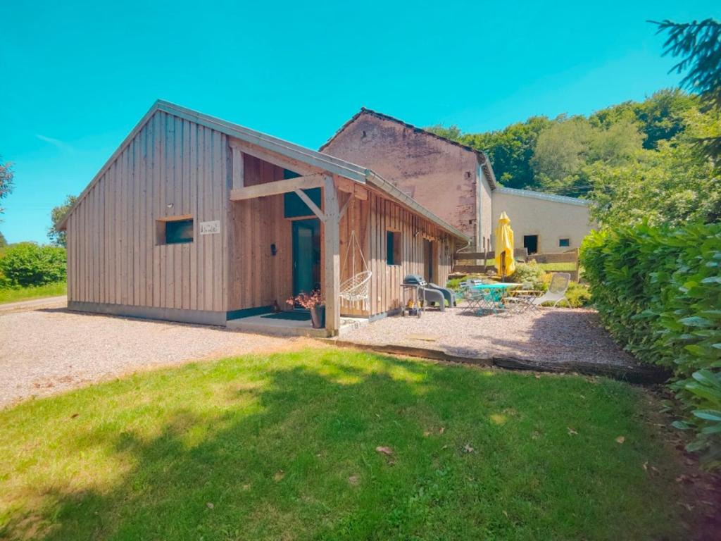 a barn with a patio and a yard at À la Volette - Cosy, Nature & Miel des Vosges in Plombières-les-Bains