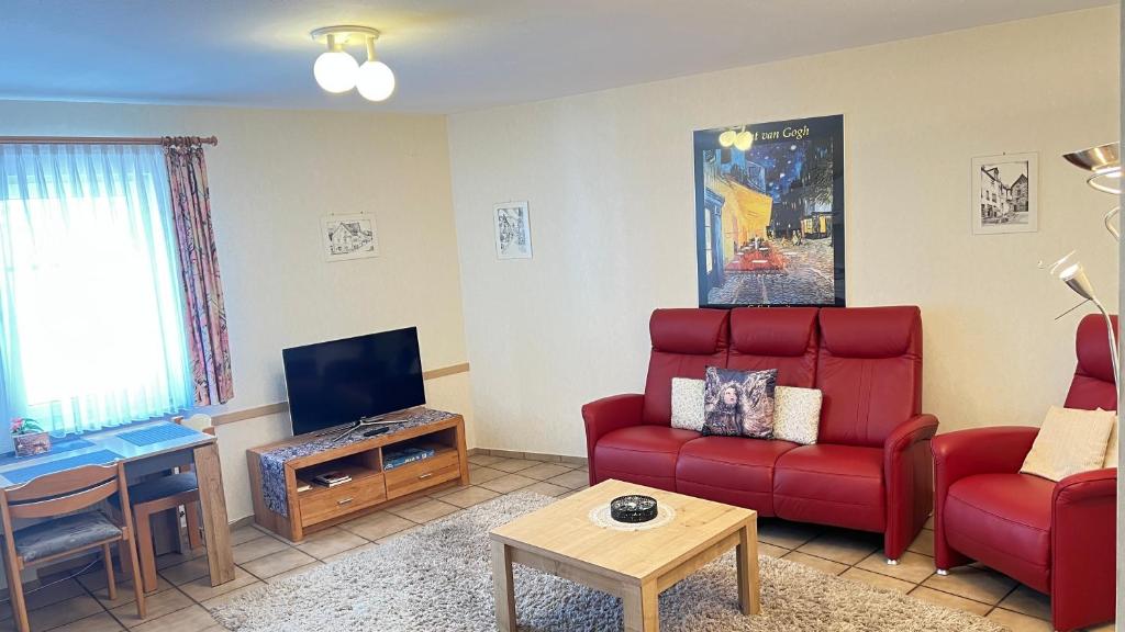 a living room with a red couch and a tv at Ferienwohnung 3 in Bernkastel-Kues