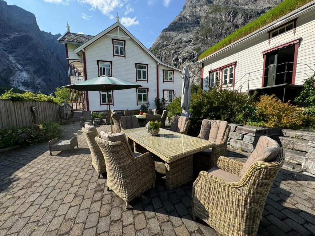 a patio with a table and chairs and a building at Horgheim Boutique Lodge, Romsdalen in Åndalsnes