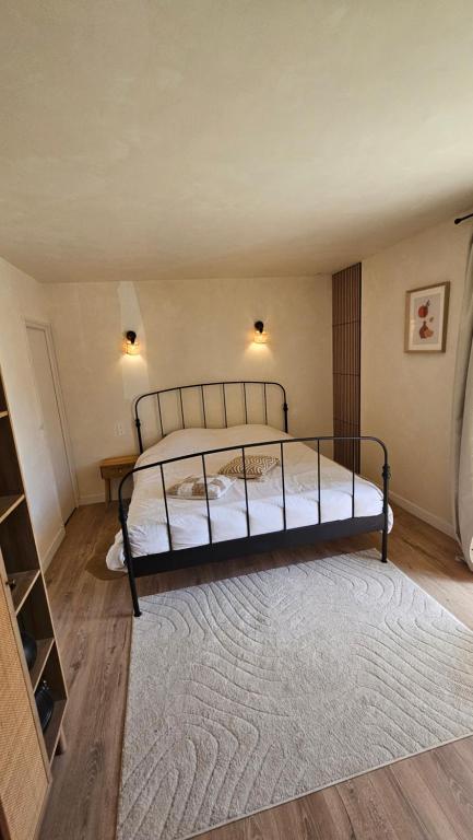 a bedroom with a bed and a rug in a room at Ker Bellevue, chambre Dinan in Lanvallay