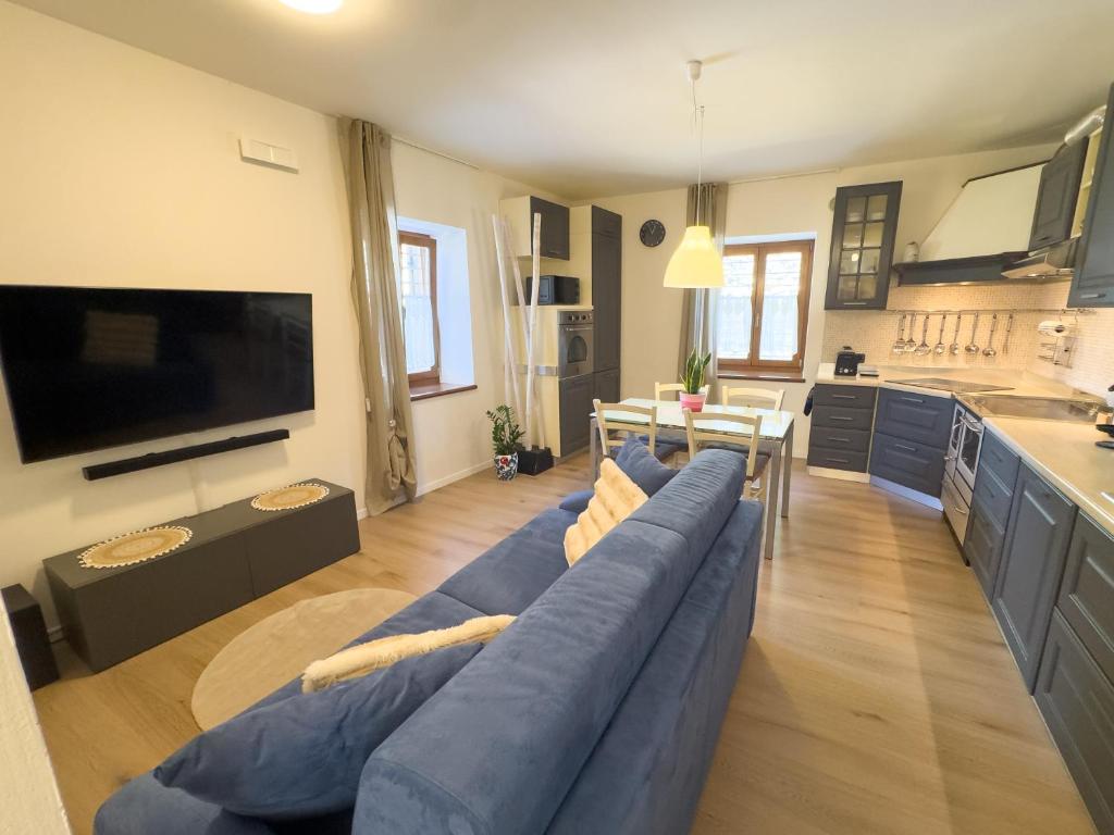 a living room with a blue couch and a kitchen at Casa del Torchio in Giovo